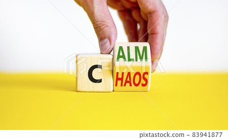 Stop chaos, time to calm. Businessman turns a wooden cube and changes the word 'chaos' to 'calm'. Beautiful white background, copy space. Business, psuchological and chaos or calm concept. 83941877