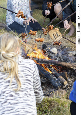 baking sausages at a scout camp 83942462