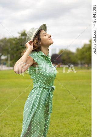 Relaxed young woman breathing fresh air in a park 83943083