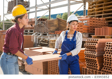 Female workers carrying brick at construction store 83943852