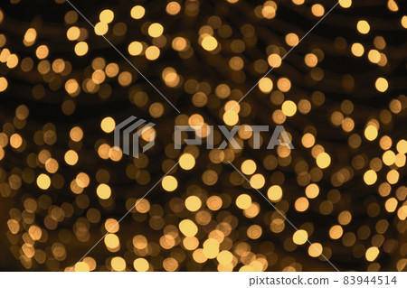 Blurred gold garland. City night light blur bokeh, defocused background. Christmas abstract. Blurred gold garland. City night light blur bokeh, defocused background. Christmas abstract. 83944514