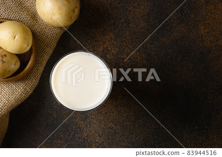 Vegan potato milk in glass, plant based milk replacer. Vegan potato milk in glass, plant based milk replacer. 83944516