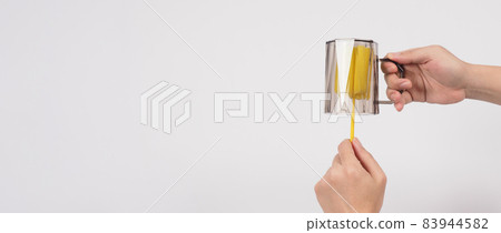 Clean and wash dish concept. Man hand washing drink glass on white background. Used drinking glass cleaning by soft yellow sponge stick. Wash cup by sponge brush. Disinfection hyginic in covid 19 era 83944582