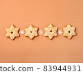 Horizontal row of star-shaped gingerbread cookies. 83944931