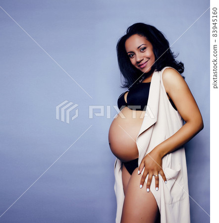 young pretty african american woman pregnant happy smiling, posing on blue background, lifestyle people concept copyspace young pretty african american woman pregnant happy smiling, posing on blue background, lifestyle people concept copyspace 83945160