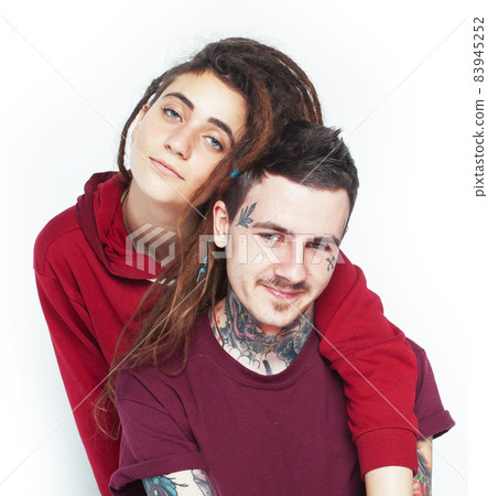 Young couple together. guy with tattoo, girlfriend wearing dreadlocks having fun on white background Young couple together. guy with tattoo, girlfriend wearing dreadlocks having fun on white background 83945252