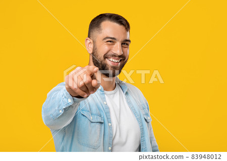 Smiling glad attractive friendly mature european male with beard showing finger to camera Smiling glad attractive friendly mature european male with beard showing finger to camera 83948012
