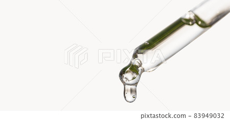 Cosmetic pipette with essential oil dropping, serum with peptides, hyaluronic acid on white background. Closeup of blue dropper, falling drop close up. Self care concept. Cosmetic pipette with essential oil dropping, serum with peptides, hyaluronic acid on white background. Closeup of blue dropper, falling drop close up. Self care concept. 83949032