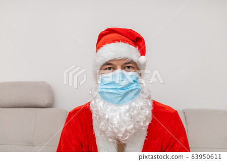 portrait man in Santa Claus hat and face mask 83950611