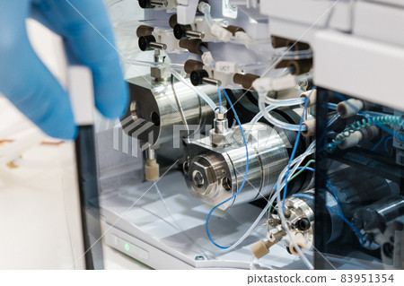 Scientist hand opens the door with binary pump for mixing for HPLC gradient formation and solvent blending. High performance liquid chromatography for separation organic compounds. 83951354