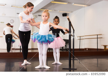 Girls practicing elements on ballet barre Girls practicing elements on ballet barre 83952090