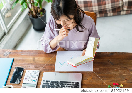 女性在客廳的辦公桌上用電腦工作 女性在客廳的辦公桌上用電腦工作 83952199