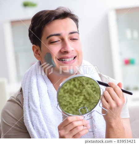 Handsome applying clay mask on face Handsome applying clay mask on face 83953421