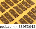 Banana and cocoa chocolate wafer roll snacks on yellow background 83953942