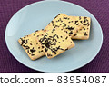 Cheese crackers with cocoa sprinkles on blue snack plate on purple tablecloth 83954087