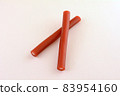 Red licorice and citrus sherbet candy tubes on pink background 83954160