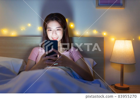 woman use smartphone on bed 83955270