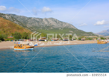 Beach umbrellas on the shore of the cozy bay of Adrasan, near Antalya and Kemer, which is in Turkey 83955514