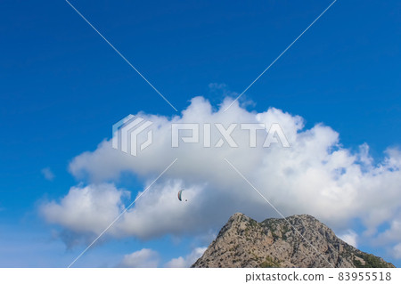 Paraglider silhouette flying over misty mountain valley in beautiful warm sunset colors - sport, active wallpapers full of freedom. Paraglider silhouette flying over misty mountain valley in beautiful warm sunset colors - sport, active wallpapers full of freedom. 83955518