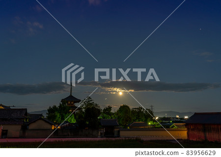 Ikaruga Town, Nara Prefecture, a harvest moon rising from the other side of the three-storied pagoda of Hokiji Temple, a World Heritage Site 83956629