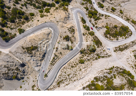 Serpentine road to Gialos Beach, Ionian Islands, Lefkada, Greece, aerial view Serpentine road to Gialos Beach, Ionian Islands, Lefkada, Greece, aerial view 83957054