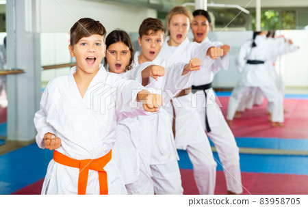 Team of motivated teenagers are engaged in karate in gym Team of motivated teenagers are engaged in karate in gym 83958705