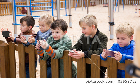 Five kidsare chatting on their smartphone Five kidsare chatting on their smartphone 83958712