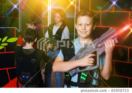 Portrait of preteen boy with laser pistol posing in laser tag la 83958723