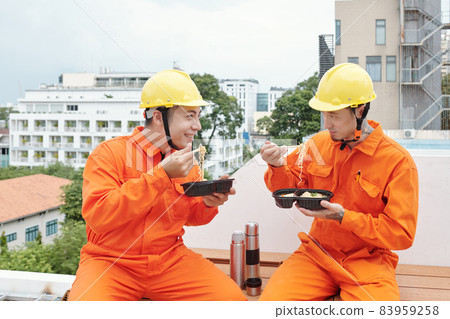 Builders Eating Lunch on House Rooftop Builders Eating Lunch on House Rooftop 83959258