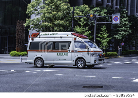An emergency vehicle (ambulance) that sounds a siren and runs in the city 83959554