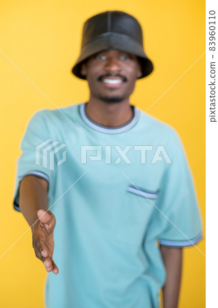 Nice meet you. Greeting hipster man. Friendly handshake. Happy guy in stylish leather hat proposing hand isolated yellow. 83960110
