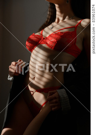 Young brunette woman in red lingerie posing in a sunshine 83961074