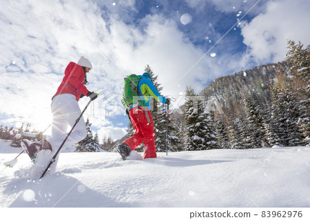 Snowshoe walkers running in powder snow with beautiful sunrise light. 83962976