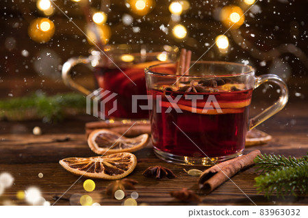 Christmas mulled red wine with spices and fruits on old wooden table. Christmas mulled red wine with spices and fruits on old wooden table. 83963032