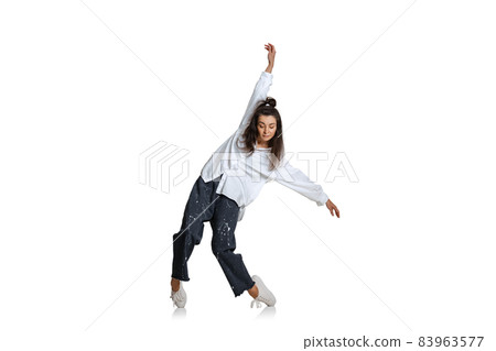 One beautiful emotive girl in casual wear moves dynamically isolated on white background. Art, motion, action, flexibility, inspiration concept. 83963577
