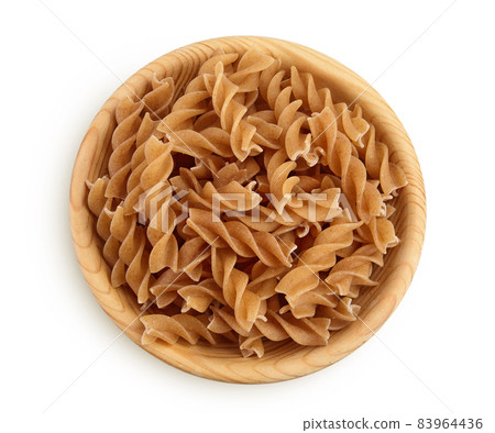 Wolegrain fusilli pasta from durum wheat in wooden bowl isolated on white background with clipping path and full depth of field. Top view. Flat lay. 83964436