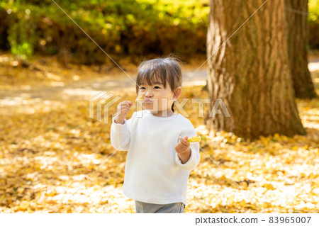 Girl enjoying the autumn leaves Girl enjoying the autumn leaves 83965007