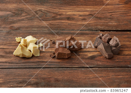 Assortment of chocolate on wooden surface 83965247