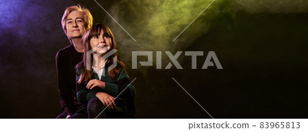 grandmother and her granddaughter with smoke and colored lights in a commercial banner for website grandmother and her granddaughter with smoke and colored lights in a commercial banner for website 83965813