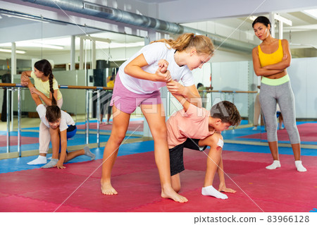 Group of kids training self-defence moves in gym 83966128