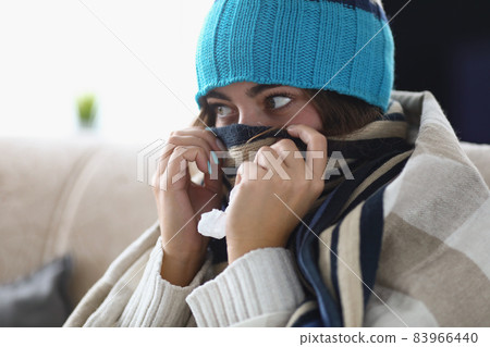 Young woman hide nose in scarf feeling cold because of high temperature Young woman hide nose in scarf feeling cold because of high temperature 83966440