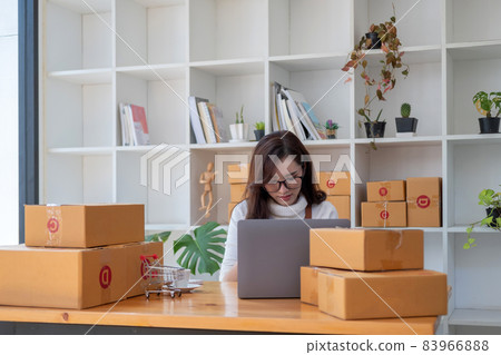 Starting Small business entrepreneur SME freelance,Portrait young woman working at home office, BOX,smartphone,laptop, online, marketing, packaging, delivery, SME, e-commerce concept. Starting Small business entrepreneur SME freelance,Portrait young woman working at home office, BOX,smartphone,laptop, online, marketing, packaging, delivery, SME, e-commerce concept. 83966888