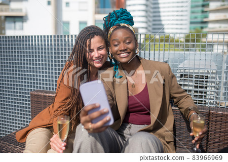 Happy businesswomen making selfie on terrace roof party 83966969