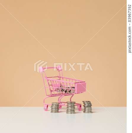 metal trolley and small change on a white table. Savings concept, discounts 83967392