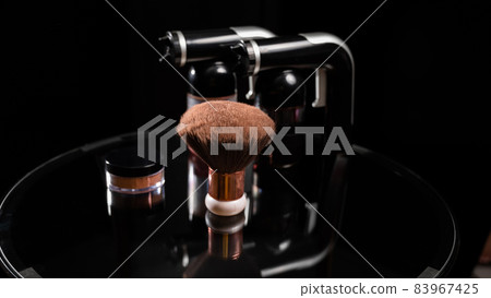 A close-up of the instant tanning equipment. Gun spraying paint for leather, brush and matting body powder on a black background. 83967425