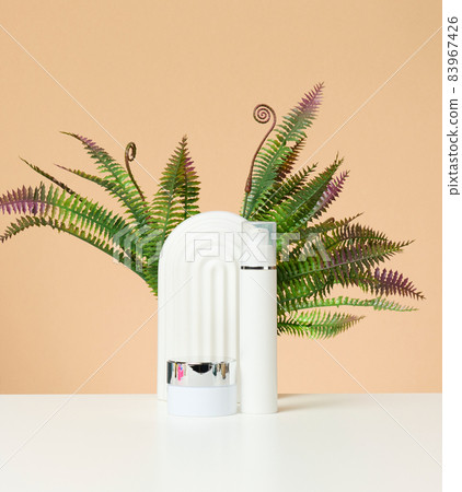 white plastic bottle and jar for cosmetics on a white table white plastic bottle and jar for cosmetics on a white table 83967426