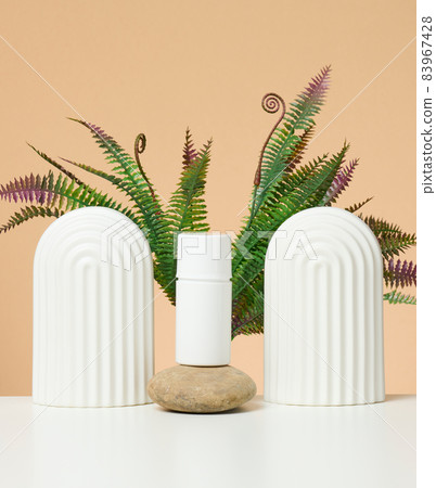 white plastic tube for cosmetic liquid products on a white table. Promotion and advertising of products white plastic tube for cosmetic liquid products on a white table. Promotion and advertising of products 83967428