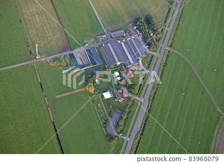 Agricultural landscape of Friesland, one of the northern provinces of the Netherlands - Friesland from above - Local farm with solar panels on roof 83968079