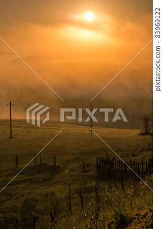 simple aerial power lines at foggy morning in summer countryside 83969122