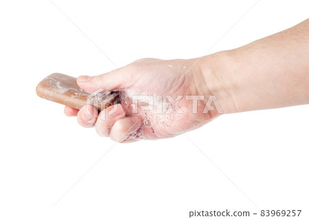 bare caucasian hand giving a wet bar of tar soap isolated on white background 83969257